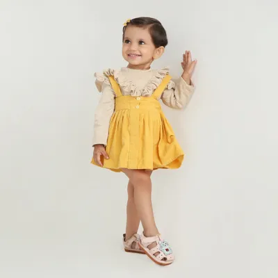 Stylish dungaree skirt paired with a cute ruffle top